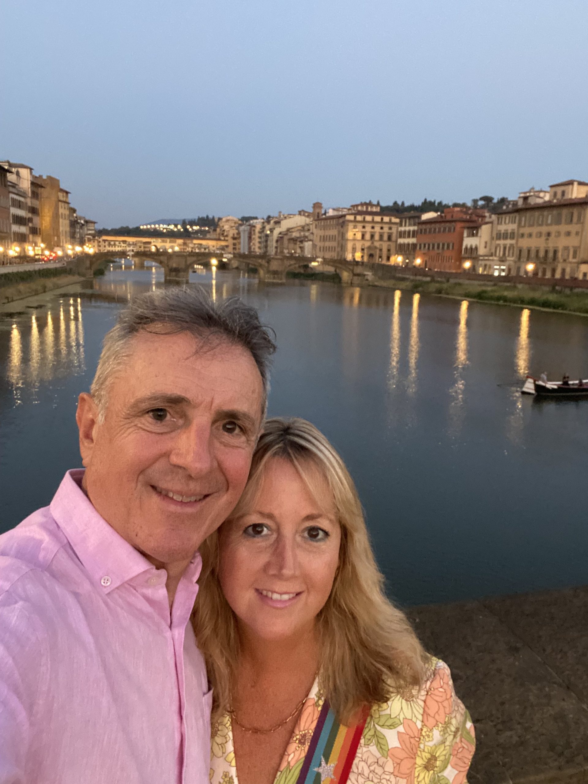 Couple pose in front of river in Florence Italy