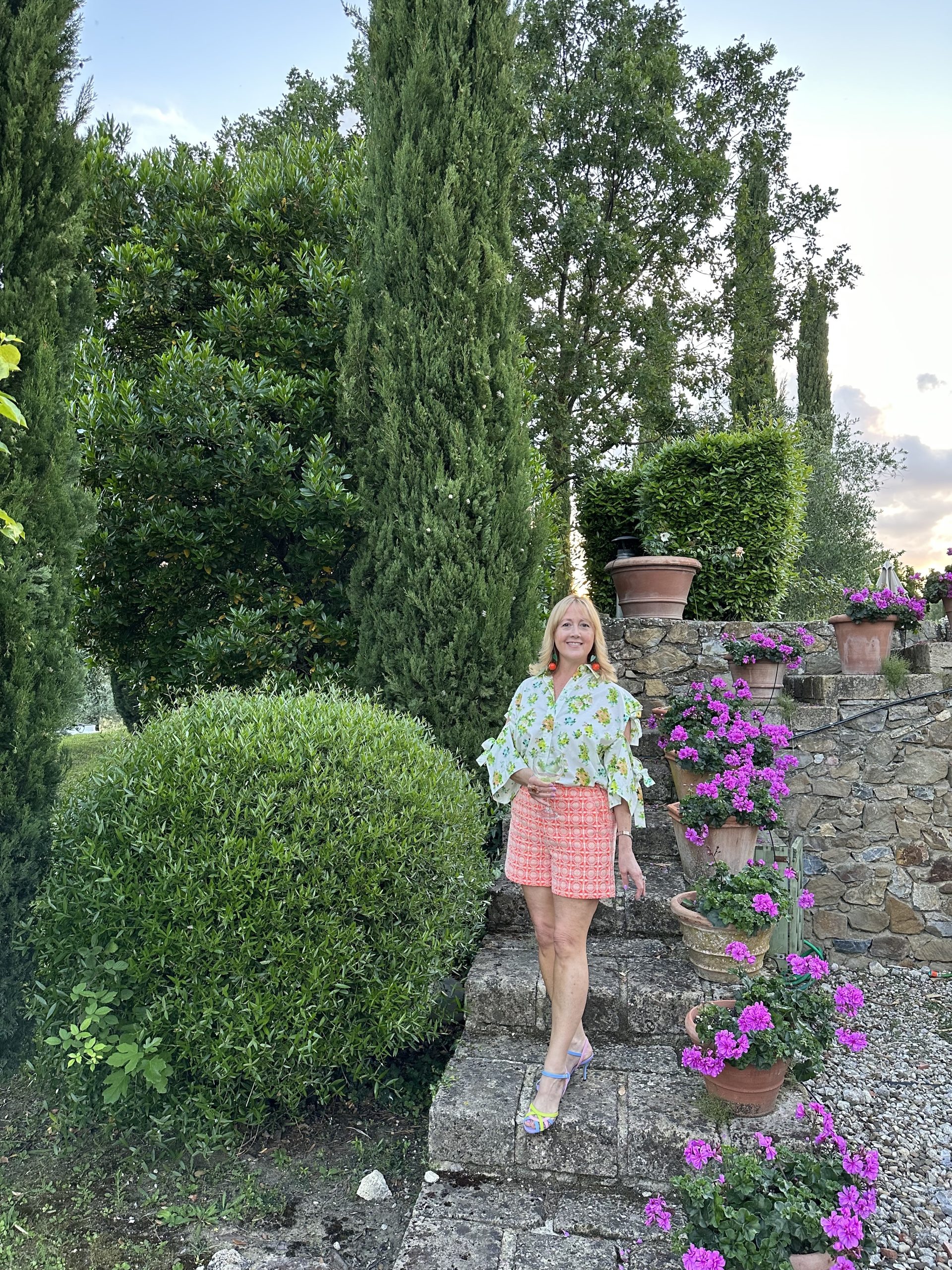 Creative Tonic in bright clothes on steps at Tuscan Villa
