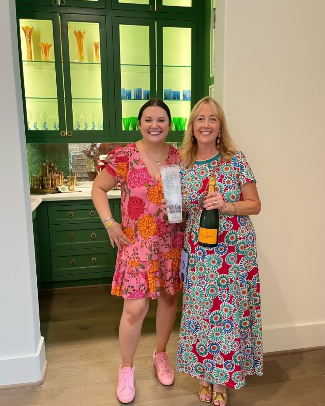 Two interior designers celebrate a successful install with champagne